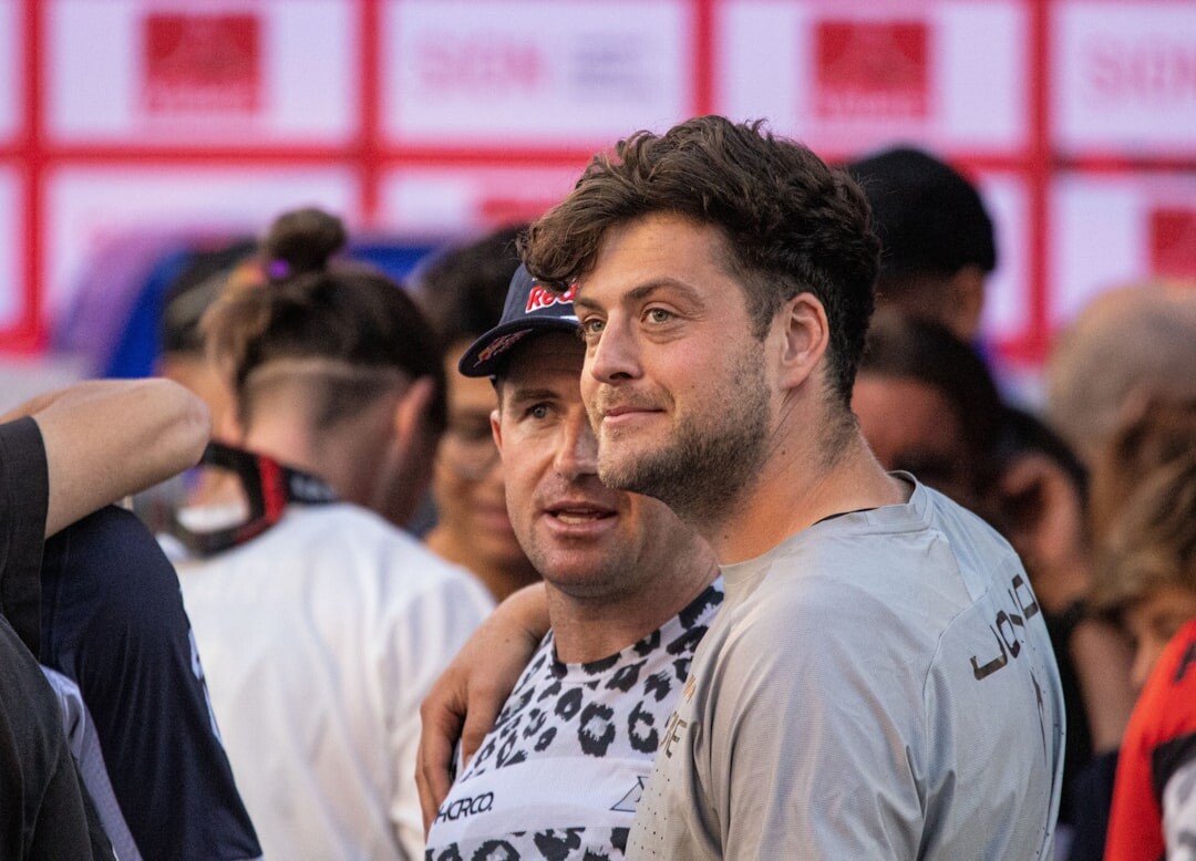 Two Swiss celebrities greeting each other warmly at an evening gala